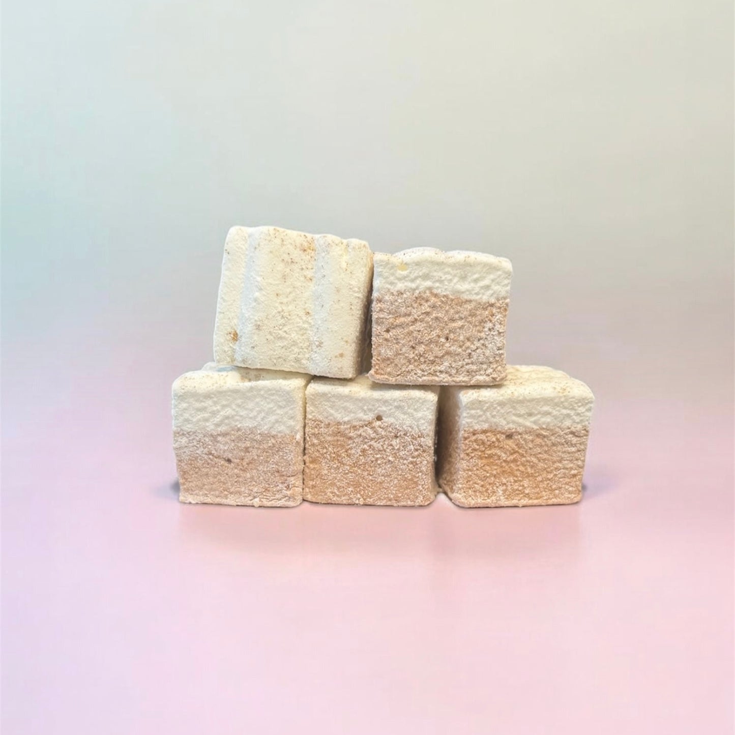 Five square marshmallows stacked on a gradient background