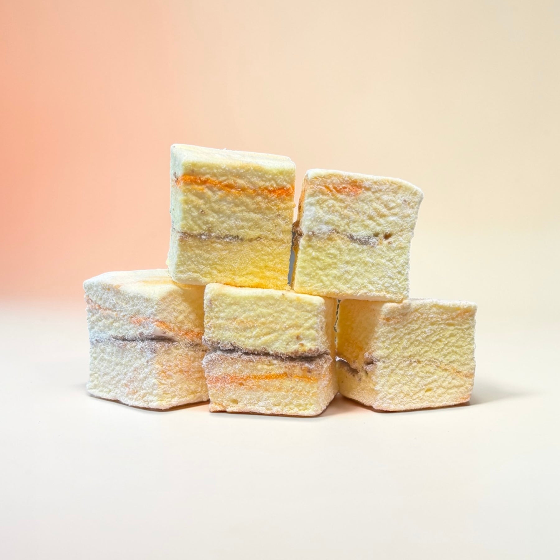 Stack of orange coloured marshmallows on a light background