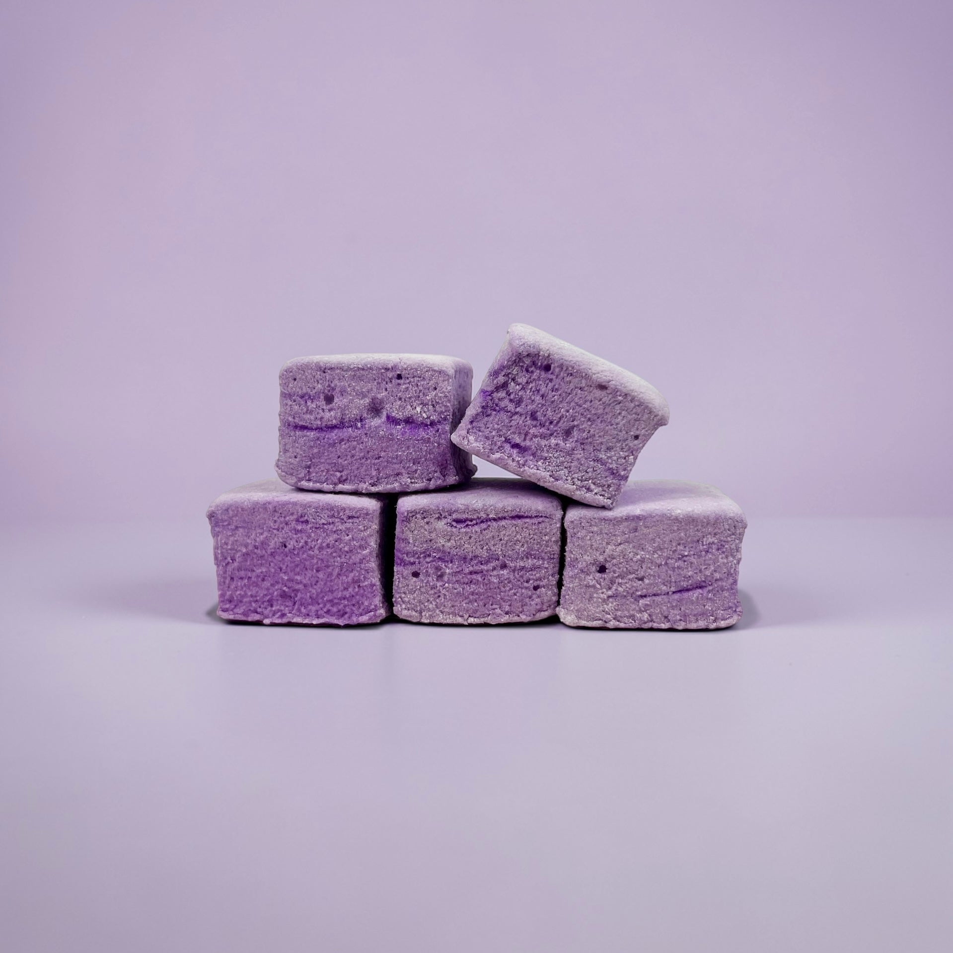Purple marshmallows stacked on a light purple background
